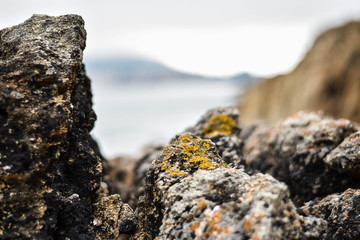 Piedras en una playa con un pueblo costero de fondo