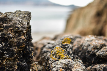 Piedras en una playa con un pueblo costero de fondo