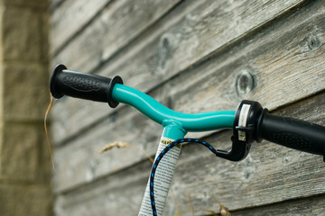 Handlebars of an electric scooter against timber background