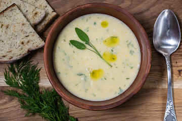 Plate of fresh homemade creamy soup with cheese, vegetables and spices.