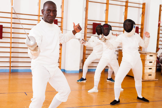 Sporty african american man fencer practicing effective fencing techniques - Powered by Adobe