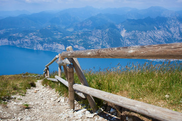Fototapeta na wymiar Above view of the Lake Garda (Lago Di Grada or Lago Benaco) from Monte Baldo, Italy. Panorama of the gorgeous Garda lake surrounded by mountains. Selective focus