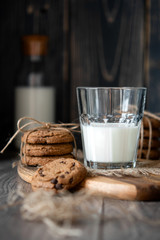 Chocolate chip cookies and milk on wooden background