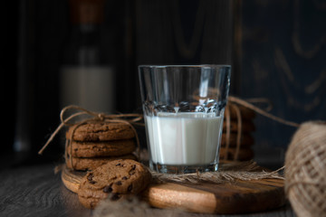 Chocolate chip cookies and milk on wooden background
