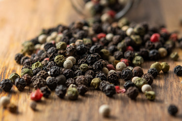 Multicolored peppers mix on a wooden table.