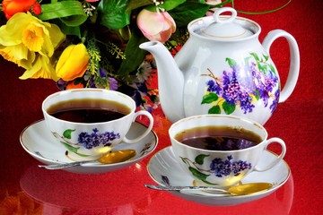 Tea party - tea in cups, teapot, garden flowers on a summer day. Daily tea is a delicious, popular, healthy, invigorating drink for Breakfast, lunch, dinner-brewing, infusion of a leaf of a tea Bush.
