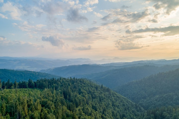 Sunset in the mountains. Forests and white clouds in the sky_1