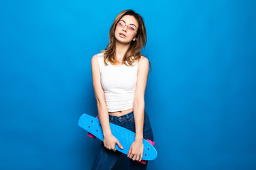 Portrait of pretty young woman in casual clothes standing, looking camera, holding skateboard...