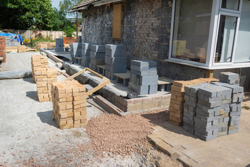 Renovation projects. Building of extension of the existing house, stacks of bricks and blocks, selective focus