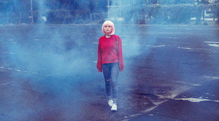 Fototapeta premium Asian teenager walking in blue smoke