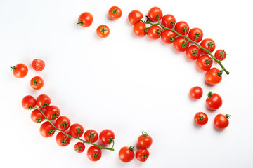 Branch of juicy organic red cherry tomatoes arranged in row on isolated white background. Polished vegetables. Clean eating concept. Vegetarian diet. Copy space, flat lay, top view.