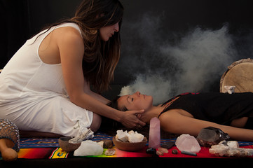 Somatic shamanic bodyworker Light Worker woman healing with sage smoke and stone crystals.  - 282311430