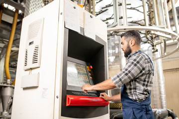 Young worker choosing settings of processing on display