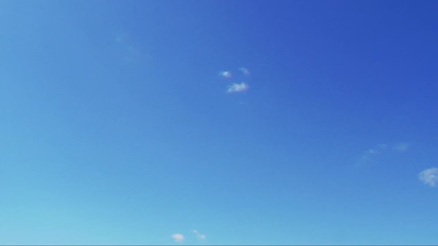 Blue sky with white clouds running by. Skyscape timelaps.
