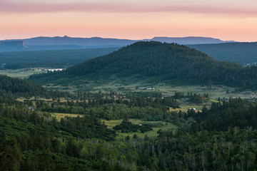Aerial view of a rural landscape of valleys, fields, farms, hills, and mountains under a beautiful sky at sunset near Pagosa Springs, Colorado