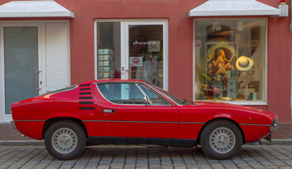 Side view of a red Italian sports car from the 70s
