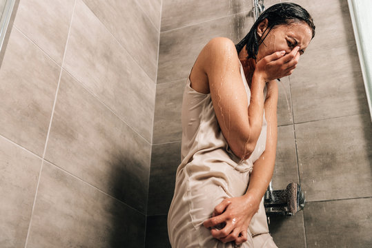 lonely sad woman crying in shower at home with copy space
