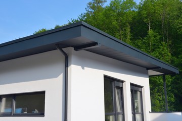 Neu errichtetes-Pultdach mit beschichteter Attika als Seitenschutz und integrierter Dachrinne