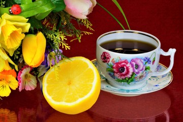 Tea in a Cup of lemon and garden flowers on a summer day. Daily tea delicious, popular, healthy, invigorating drink for Breakfast, lunch, dinner-brewing. Lemon-citrus, sour taste, vitamins and cooking