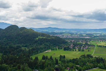 Fototapeta na wymiar Panaramic skyline of Alps, Bavaria. Spring summer time. Postcard view. Blue sky and green fields.