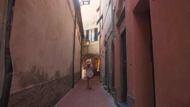 Woman walking along an old Italian city laneway. SLOW MOTION