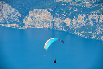 Paraglider flying over the Garda Lake (Lago di Garda or Lago Benaco), Panorama of the gorgeous...