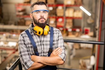Fototapeta premium Serious warehouse worker in protective eyewear and headphones