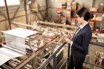 Young quality control expert with touchpad testing new industrial equipment