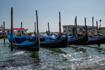 Fototapeta na wymiar Gondolas paradas ou atracada no canal de Veneza no mar, Italia