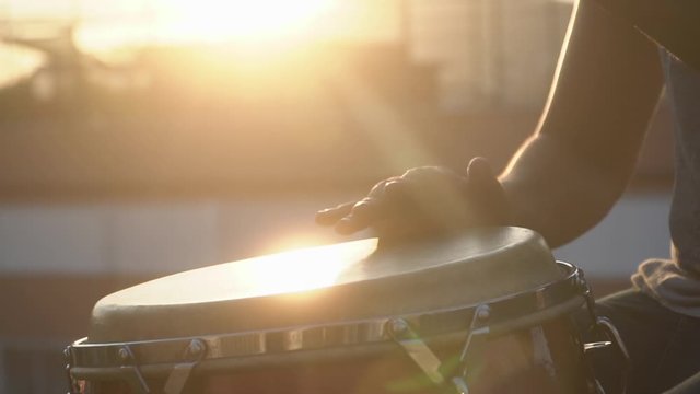 closeup of hands playing drums with a bongo
