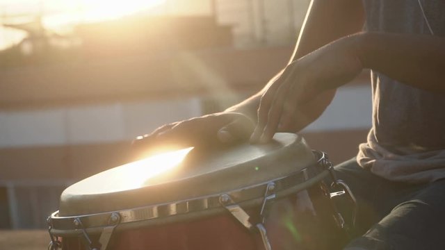 closeup of hands playing drums with a bongo