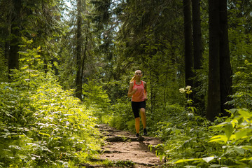 Obraz premium young woman jogging in a mountain forest