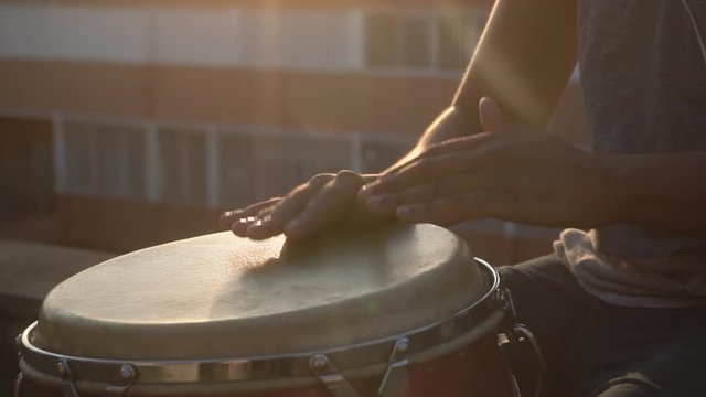 closeup of hands playing drums with a bongo