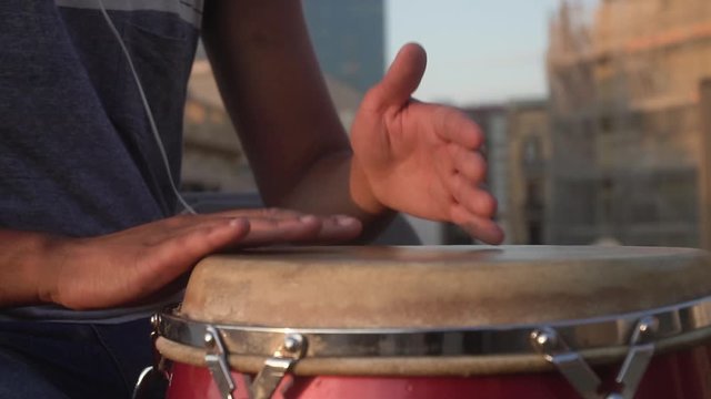 closeup of hands playing drums with a bongo