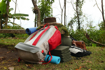Equipment for camping on a grass - backpack, tent, sleeping bags, mats and other stuff for comfortable camping life.