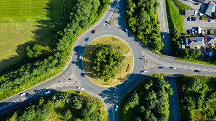 Aerial long exposure of traffic on a roundabout in a small town - obrazy, fototapety, plakaty