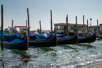 Fototapeta na wymiar Gondolas paradas ou atracadas no canal de Veneza, Italia