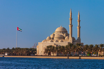 Al Noor Mosque on the bank of Khalid Lake with UAE flag not far away, Sharjah, United Arab Emirates