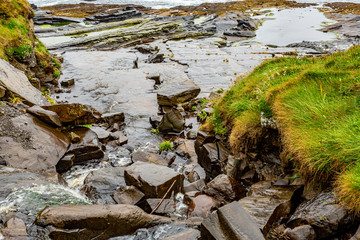 Rocks in the coastal area along the coastal walk route from Doolin to the Cliffs of Moher, geosites and geopark, Wild Atlantic Way, rainy day in county Clare in Ireland