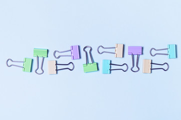 Different bright paper clip pattern on pink background. Top view, flat lay. Minimal school or office stationery.