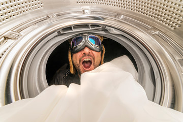 washing machine and spin. Man with aviator glasses, quick wash concept. Interior of washing machine drum with metallic glitters washing a white cloth