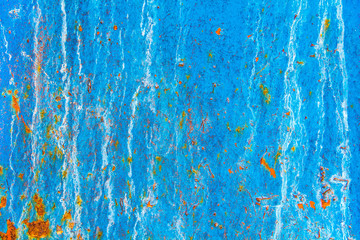 Texture of an old metal blue wall with rust, scratches, cracks, smudges and peeling paint.