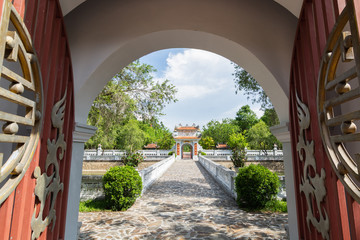 Hue, Vietnam - June 2019: view over traditional Vietnamese temple through open decorated entrance doors