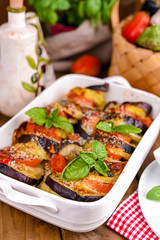 Traditional italian food. Baked eggplant, tomatoes with sauce, parmesan and basil. Rustic food for a healthy diet. Vegetables for lunch.