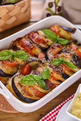 Traditional italian food. Baked eggplant, tomatoes with sauce, parmesan and basil. Rustic food for a healthy diet. Vegetables for lunch.