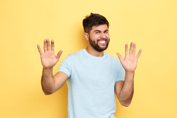 angry frustrated man showing his palms, isolated yellow background, studio shot, guy retracting a claim