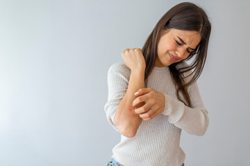 Women scratch the itch with hand , Concept with Healthcare And Medicine. Woman scratching arm on grey background. Allergy symptoms. Woman scratching her arm. - obrazy, fototapety, plakaty