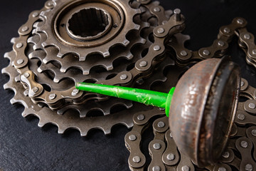 Oiling the bicycle chain with an oil can on the workshop table. Servicing of bicycle parts.