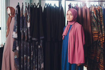 Arab woman in traditional Muslim clothes buys a new dress in an Oriental store.