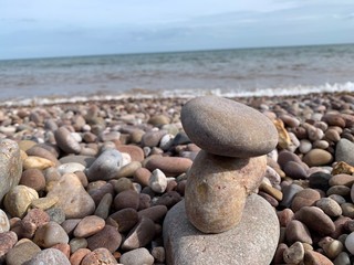 Fototapeta na wymiar Stacked pebbles with waves on the beach